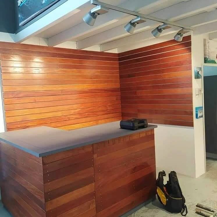 Office reception desk with timber cladding and track lighting in Durban