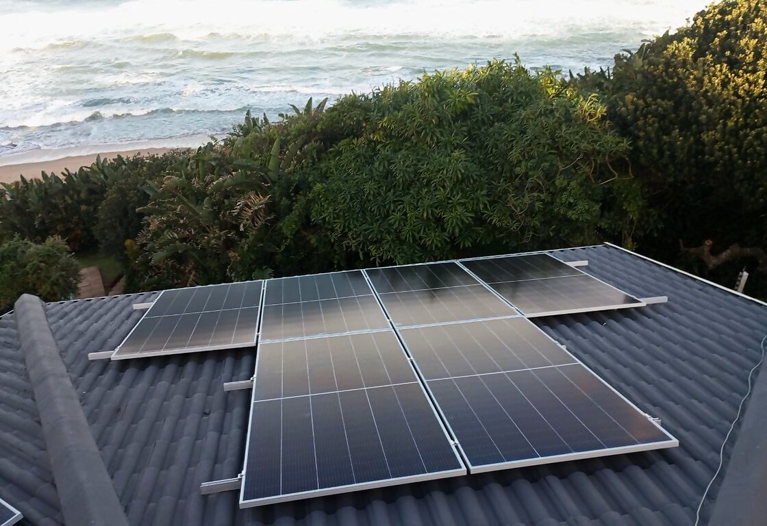 Tier-1 solar panels on a tiled roof overlooking the Durban coastline